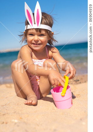 Happy girl with bunny hairband on the beach  86904959