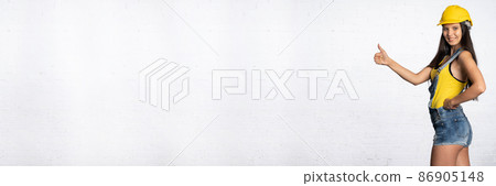 A construction worker shows with her thumb that everything is fine. Positive signs and symbols shown with her hand. A construction worker shows with her thumb that everything is fine. Positive signs and symbols shown with her hand. 86905148