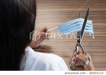 A young virologist decided to cut the protective mask as a sign of the end of the pandemic and the reign of the COVID-19 flu. 86905214