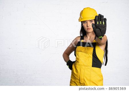 A young construction worker clearly shows that you cannot get close to this place. Occupational Health and Safety. Restraining order. Stop. A young construction worker clearly shows that you cannot get close to this place. Occupational Health and Safety. Restraining order. Stop. 86905369