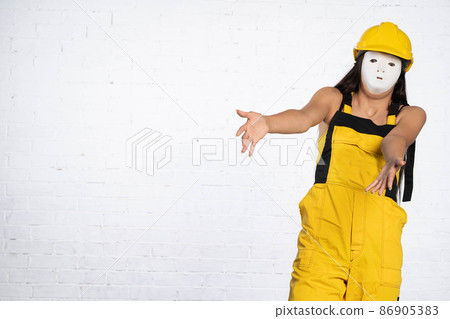 An anonymous construction worker asks who did it and who will restore it to its original state. Working clothes and a protective helmet. 86905383