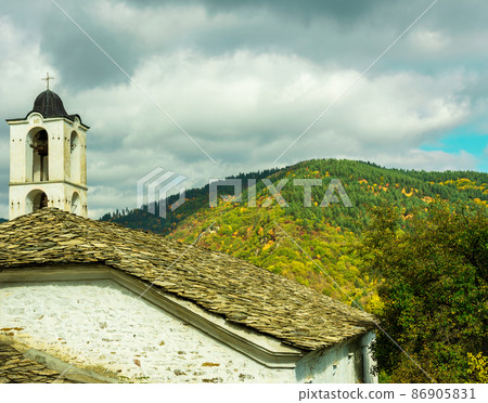 Old traditional Bulgarian church in mountain village of Kovachevitsa. Traditional slan stone roofs Old traditional Bulgarian church in mountain village of Kovachevitsa. Traditional slan stone roofs 86905831
