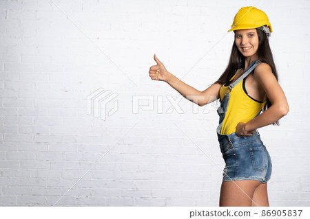 A construction worker shows with her thumb that everything is fine. Positive signs and symbols shown with her hand. A construction worker shows with her thumb that everything is fine. Positive signs and symbols shown with her hand. 86905837
