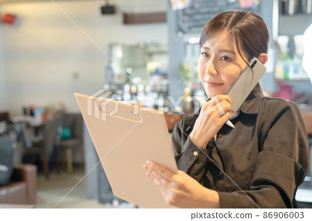 Busy female clerk to contact with smartphone Busy female clerk to contact with smartphone 86906003