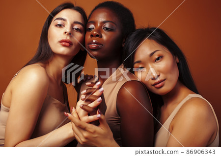 young pretty caucasian, african, scandinavian woman posing cheerful together on brown background, lifestyle diverse nationality people concept young pretty caucasian, african, scandinavian woman posing cheerful together on brown background, lifestyle diverse nationality people concept 86906343