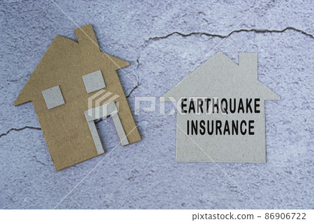 Earthquake insurance text on paper house model. Home insurance concept. 86906722