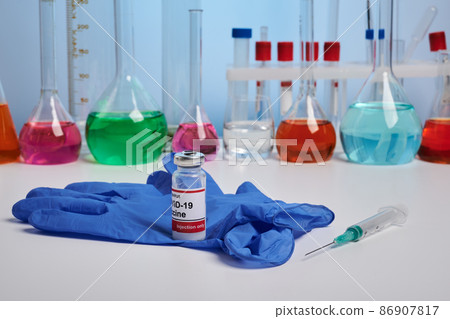 Coronavirus Vaccine and Glove on Chemical Desk Coronavirus Vaccine and Glove on Chemical Desk 86907817