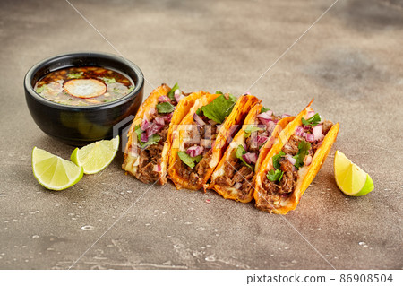 Traditional mexican birria consome soup and four taco with stewed beef 86908504