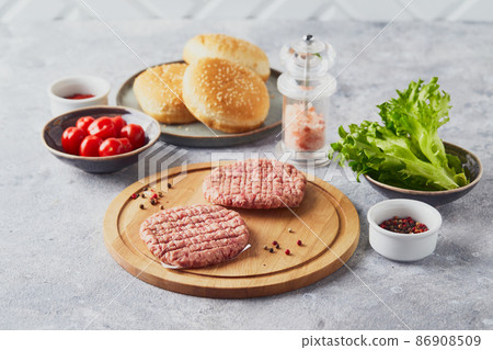 Raw veal mince Burger steak cutlets on wooden cutting board Raw veal mince Burger steak cutlets on wooden cutting board 86908509