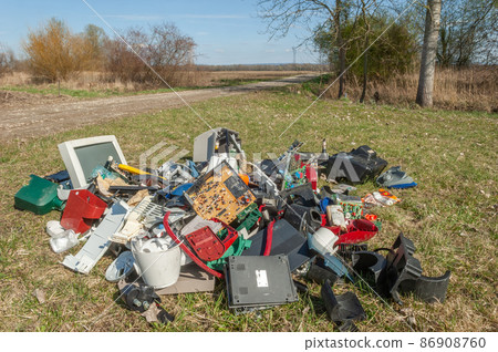 Waste polluting plastics and computer equipment dumped in a meadow. Waste polluting plastics and computer equipment dumped in a meadow. 86908760