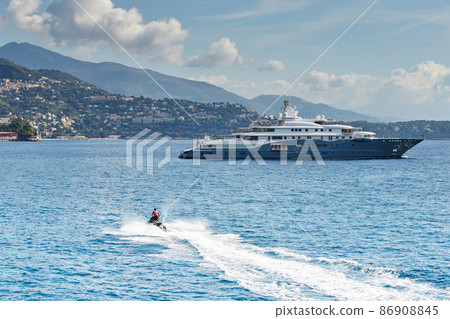 Monaco, Monte-Carlo, most expensive mega yacht on sea, sunny day, Jet Ski, mountains on background Monaco, Monte-Carlo, most expensive mega yacht on sea, sunny day, Jet Ski, mountains on background 86908845
