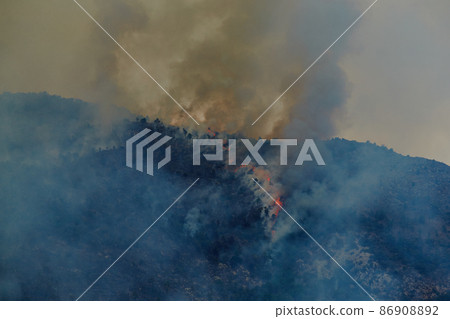 Fire in the forest mountain in the Italian town of Ventimiglia, all the mountains in the smoke, the villa is on fire, the fire service aircraft extinguish a fire 86908892
