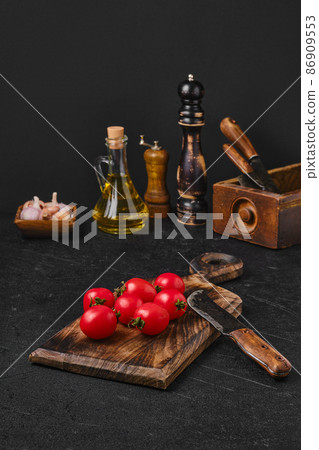 Fresh small whole tomatoes on wooden cutting board Fresh small whole tomatoes on wooden cutting board 86909553