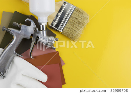 Paint spray gun at work at the workplace in the workshop. Paint Brush 86909708