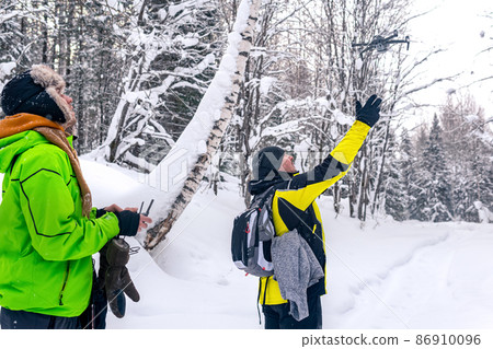 two men in the winter forest launch a quadcopter two men in the winter forest launch a quadcopter 86910096