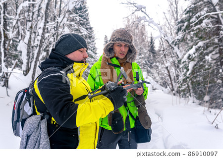 two men in the winter forest launch a quadcopter two men in the winter forest launch a quadcopter 86910097