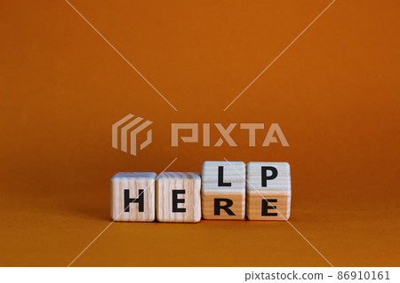 Help is here symbol. Turned wooden cubes and changed the word help to here. Beautiful orange background, copy space. Business, support, motivational and help is here concept. 86910161
