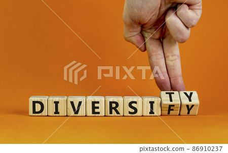 Diversity or diversify symbol. Businessman turns wooden cubes and changes the word 'diversify' to 'diversity'. Beautiful orange background, copy space. Business and diversity or diversify concept. Diversity or diversify symbol. Businessman turns wooden cubes and changes the word 'diversify' to 'diversity'. Beautiful orange background, copy space. Business and diversity or diversify concept. 86910237