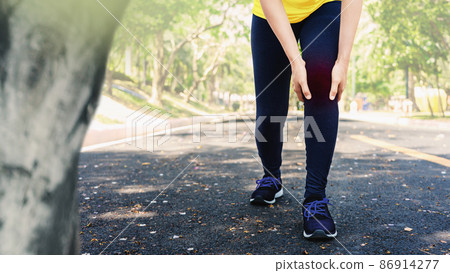 Young sport woman hold her injured knee in outdoors. 86914277
