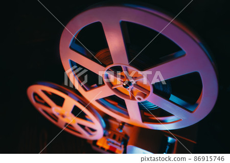Film reels turning. Analog player, cans with tape. Retro old-fashioned 8mm projector playing movie Film reels turning. Analog player, cans with tape. Retro old-fashioned 8mm projector playing movie 86915746