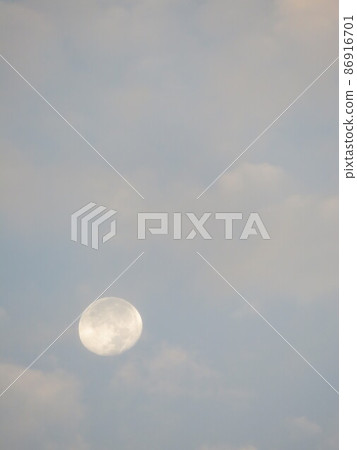 白天從多雲的天空瞥見白朦朧的月亮 86916701