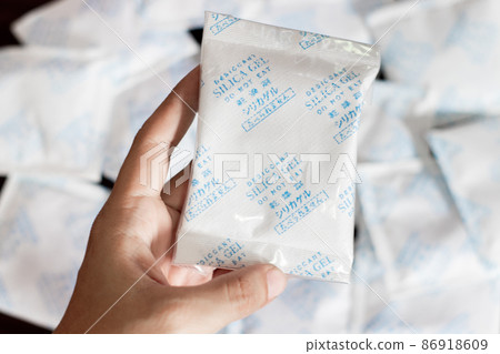 Desiccant gel bag on hand with Silica backgrounds Desiccant gel bag on hand with Silica backgrounds 86918609