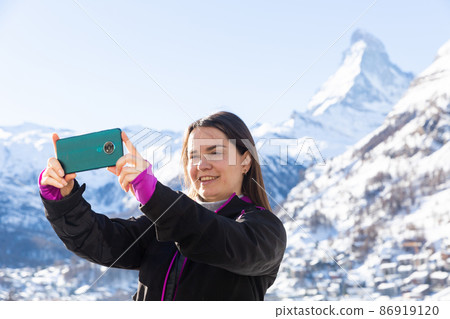 Happy traveler woman recording video of mountain views on mobile phone Happy traveler woman recording video of mountain views on mobile phone 86919120