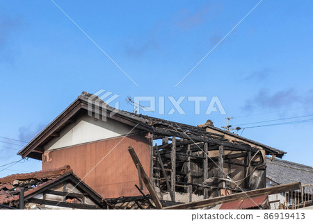 fire. A fire site of a house burned by a fire against a blue sky background. 86919413