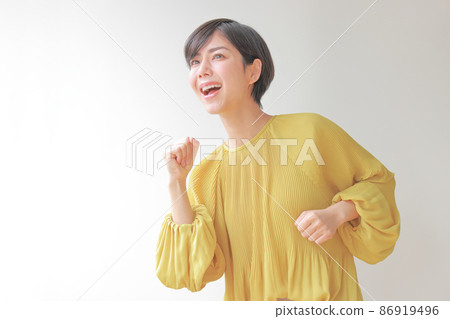 A woman who looks diagonally forward with a stance to start running 3 A woman who looks diagonally forward with a stance to start running 3 86919496