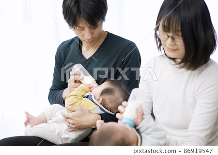 Asian parents feeding twin babies milk Asian parents feeding twin babies milk 86919547