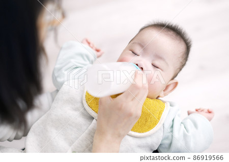 Asian baby drinking milk while sleeping 86919566