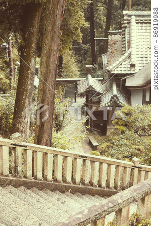 一張復古風格的照片，一張舊樓梯通往近江地區山區的一座山寺。 86919988