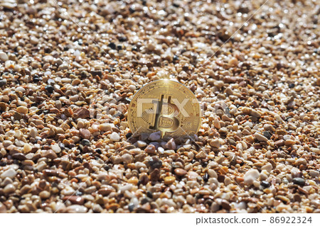 The bitcoin on the sandy seashore. The concept of freelance and cryptocurrency The bitcoin on the sandy seashore. The concept of freelance and cryptocurrency 86922324