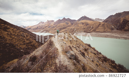 Woman backpacker hiking in winter plateau mountains Woman backpacker hiking in winter plateau mountains 86922727