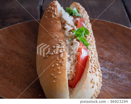 雞肉三明治。使用櫻島通將醃製雞肉、西紅柿和生菜夾在中間的法式長棍麵包。 雞肉三明治。使用櫻島通將醃製雞肉、西紅柿和生菜夾在中間的法式長棍麵包。 86923294