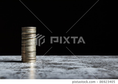 Stack of coins on grey table and black background. Venture capital concept with copy space Stack of coins on grey table and black background. Venture capital concept with copy space 86923405