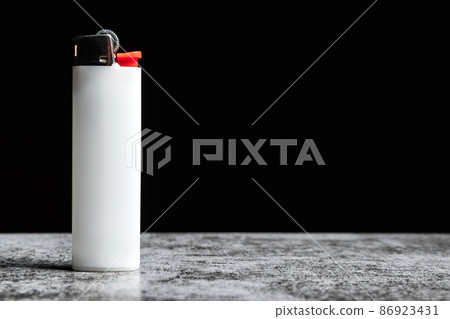 White cigarette lighter on grey table on black background with copy space 86923431