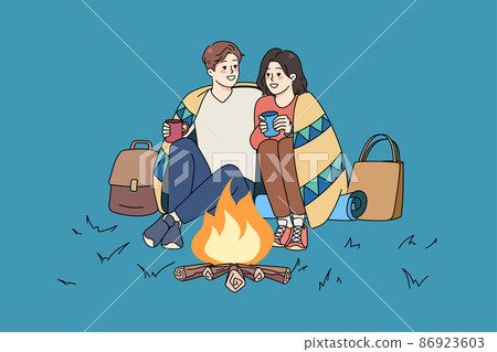 Happy couple sit near fire on romantic date  86923603