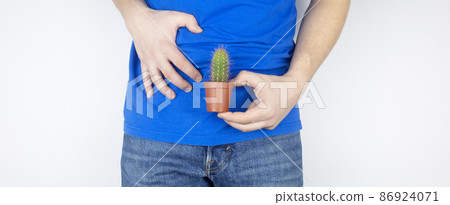 Concept. A man holds a cactus near his fly. Problems of the genitourinary system. Prostatitis. Painful bowel movements. Men problems. Oncology. Prostate problems Concept. A man holds a cactus near his fly. Problems of the genitourinary system. Prostatitis. Painful bowel movements. Men problems. Oncology. Prostate problems 86924071