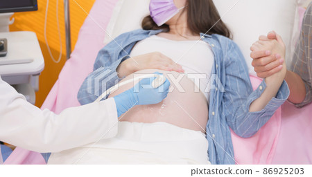 pregnant woman have ultrasound scan 86925203