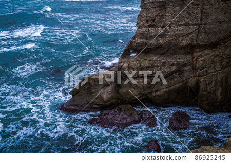 被洶湧的海浪摩擦的陡峭岩石 被洶湧的海浪摩擦的陡峭岩石 86925245