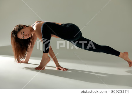 Sporty young woman doing yoga practice isolated on white background - concept of healthy life and natural balance between body and mental development. 86925374