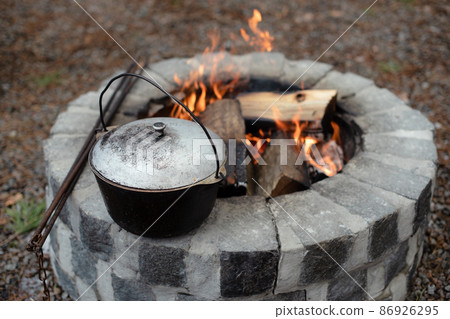 Food in the pot over the fire, tourist camp, preparing food. Camp hot food for tourists in the forest. Food in the pot over the fire, tourist camp, preparing food. Camp hot food for tourists in the forest. 86926295