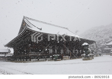 The precincts of the snow scene where you can see the main hall of the temple where snow falls from the winter sky and the scenery where you can see the mountains The precincts of the snow scene where you can see the main hall of the temple where snow falls from the winter sky and the scenery where you can see the mountains 86928918