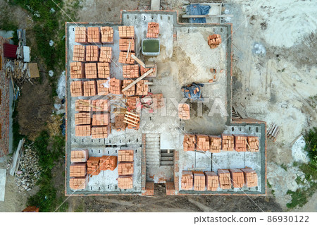 Top down aerial view of building works of new house concrete foundation on construction site. Top down aerial view of building works of new house concrete foundation on construction site. 86930122