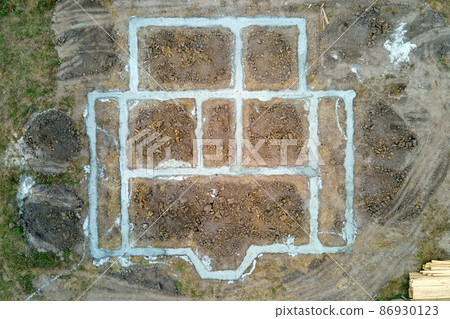 Top down aerial view of building works of new house concrete foundation on construction site. Top down aerial view of building works of new house concrete foundation on construction site. 86930123