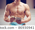Cash dollars money in the hands of a muscular young man 86930941