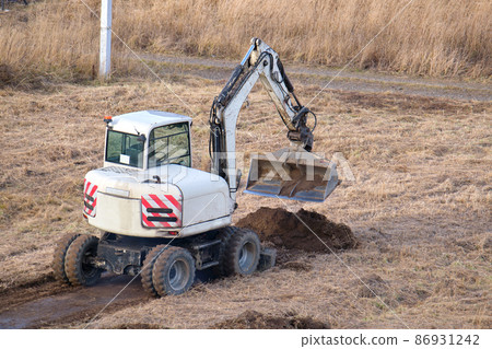 Earth moving tractor preparing place for future house foundation construction. Leveling soil for building new home 86931242