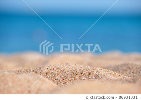 Close up of clean yellow sand surface covering seaside beach with blue sea water on background. Travel and vacations concept. Close up of clean yellow sand surface covering seaside beach with blue sea water on background. Travel and vacations concept. 86931331