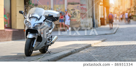Close up of a motorcycle parked on city street side. 86931334